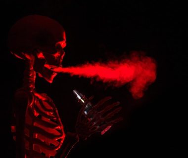 Stylised skeleton exhaling red vapour, illustrating how nicotine travels through the body