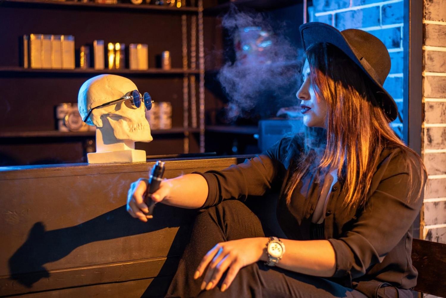 Woman using a pod vape in a lounge setting, showing modern nicotine salt devices